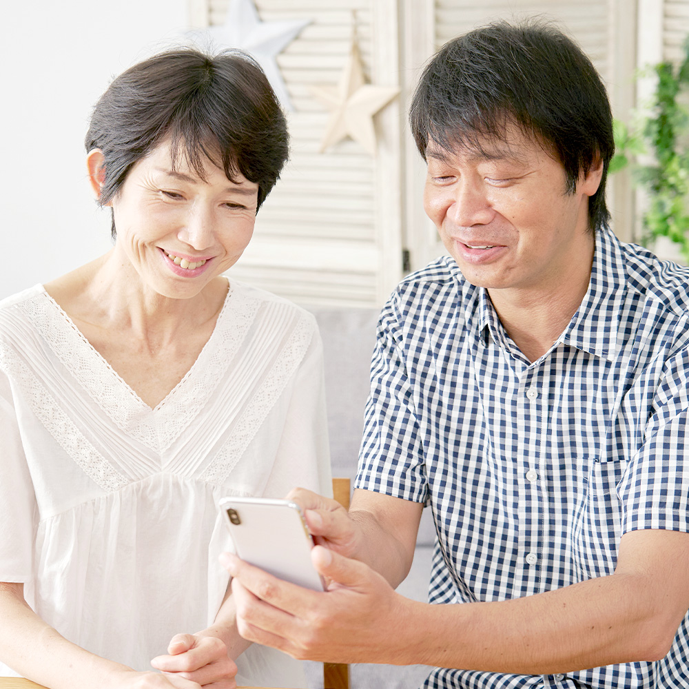 スマホを見て話す夫婦