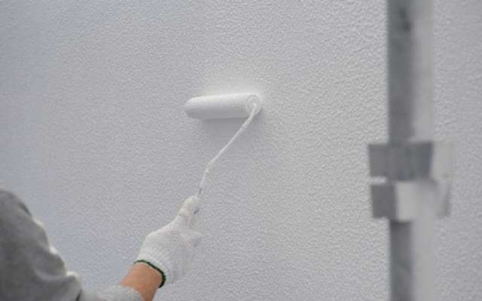 ローラーで外壁を塗装する様子