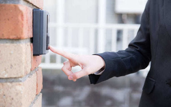 訪問業者がインターホンを押す様子