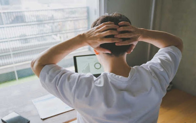 画面をみて悩む男性