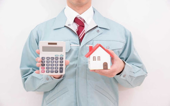 電卓とモデルを持った作業員